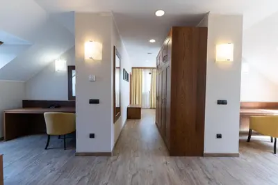 a hallway in a house with white walls and wooden floors at Hotel Arena Maribor in Maribor