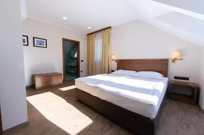 a bedroom with a large bed with white sheets at Hotel Arena Maribor in Maribor