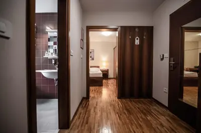 a hallway with a bathroom and a sink in a room at Hotel Dvor Jezersek Brnik in Cerklje na Gorenjskem