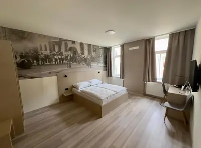 a bedroom with a bed and a desk in it at Hotel Evropa in Celje