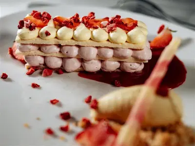 a piece of cake with strawberries on a white plate at Hotel Evropa in Celje
