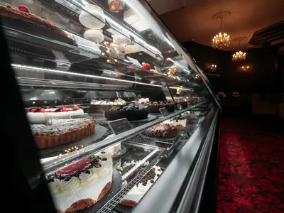 a display case with cakes and other desserts at Hotel Evropa in Celje
