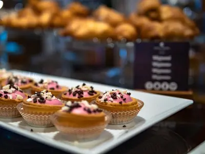 a tray of cupcakes with pink frosting and sprinkles at Hotel Evropa in Celje