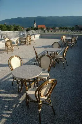 a group of tables and chairs on a patio at Hotel Krek Superior in Lesce