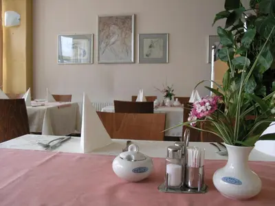 a table with a pink table cloth with a vase of flowers at Hotel Krek Superior in Lesce
