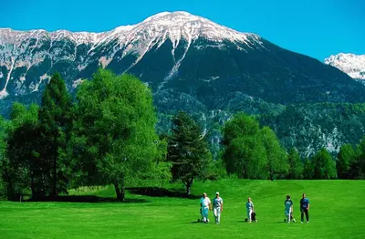 a group of people standing in a field in front of a mountain at Hotel Krek Superior in Lesce