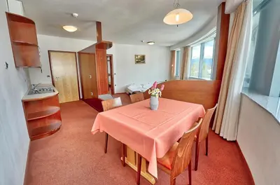 a kitchen and dining room with a table and chairs at Hotel Krek Superior in Lesce