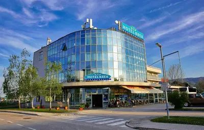 a large glass building with a sign on top of it at Hotel Krek Superior in Lesce
