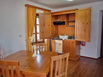 a kitchen with a wooden table and wooden cabinets at Wine Grower's Mansion Zlati Gric in Slovenske Konjice