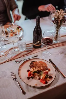a plate of food on a table with a bottle of wine at Wine Grower's Mansion Zlati Gric in Slovenske Konjice