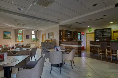 a restaurant with tables and chairs and a bar at Garni Hotel Zvon in Zreče