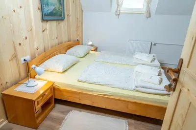 a bedroom with a wooden bed with towels on it at Pension Cerkovnik in Bohinj
