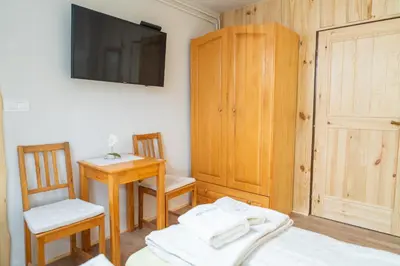 a bedroom with a bed and a table and a tv at Pension Cerkovnik in Bohinj