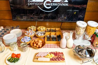 a table topped with plates and bowls of food at Pension Cerkovnik in Bohinj
