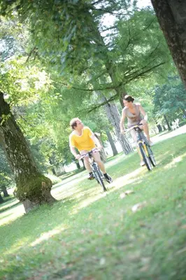 two men riding bikes in a park at Grand Hotel Rogaska in Rogaška Slatina