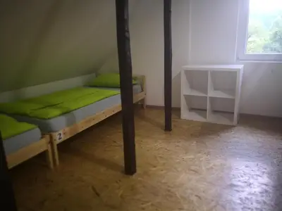 a bedroom with a bed with green sheets and a window at Bus Station Beds in Bled