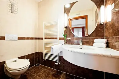 a bathroom with a sink and a toilet and a mirror at Hotel Livada Prestige - Terme 3000 - Sava Hotels & Resorts in Moravske Toplice