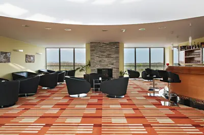 a waiting room with chairs and a fireplace at Hotel Livada Prestige - Terme 3000 - Sava Hotels & Resorts in Moravske Toplice