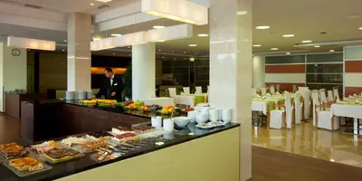 a buffet line with food and a man in a restaurant at Hotel Livada Prestige - Terme 3000 - Sava Hotels & Resorts in Moravske Toplice