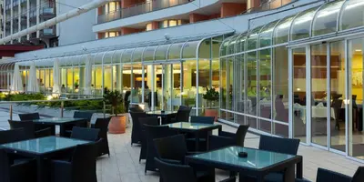 a restaurant with tables and chairs in front of a building at Hotel Livada Prestige - Terme 3000 - Sava Hotels & Resorts in Moravske Toplice