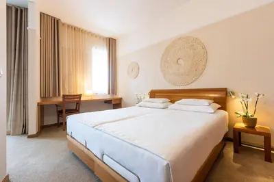 a bedroom with a large bed and a desk at Hotel Livada Prestige - Terme 3000 - Sava Hotels & Resorts in Moravske Toplice