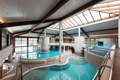 a large indoor pool in a building with windows at Hotel Termal - Terme 3000 - Sava Hotels & Resorts in Moravske Toplice