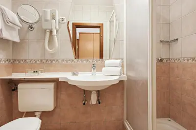 a bathroom with a sink and a toilet and a mirror at Hotel Termal - Terme 3000 - Sava Hotels & Resorts in Moravske Toplice