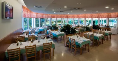 a dining room with tables and chairs and windows at Hotel Termal - Terme 3000 - Sava Hotels & Resorts in Moravske Toplice