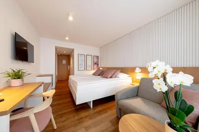 a room with a bed and a table and a couch at Hotel Termal - Terme 3000 - Sava Hotels & Resorts in Moravske Toplice