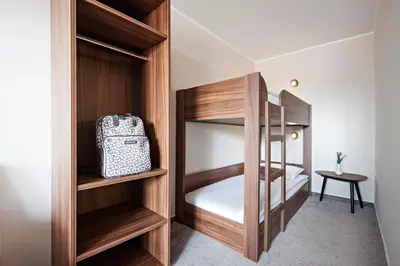a small bedroom with wooden bunk beds and a table at Hotel Ajda - Terme 3000 - Sava Hotels & Resorts in Moravske Toplice