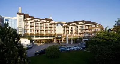a large building with cars parked in a parking lot at Hotel Ajda - Terme 3000 - Sava Hotels & Resorts in Moravske Toplice
