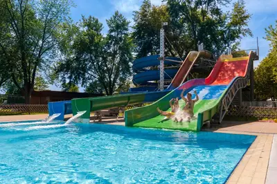 a pool with a water slide in a park at Hotel Ajda - Terme 3000 - Sava Hotels & Resorts in Moravske Toplice