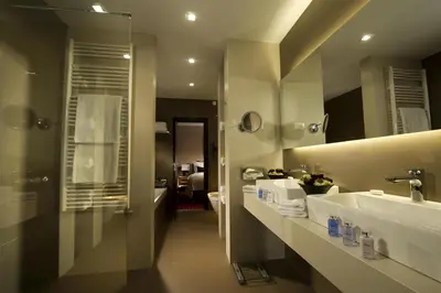 a bathroom with two sinks and a large mirror at Best Western Premier Hotel Slon in Ljubljana