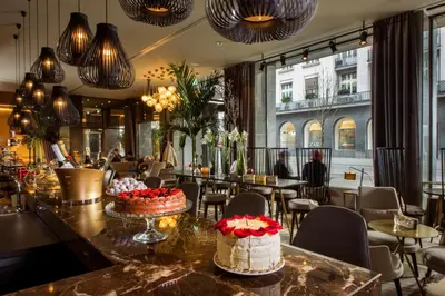 a restaurant with cakes on a counter with tables and chairs at Best Western Premier Hotel Slon in Ljubljana