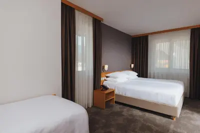 a hotel room with two beds and a window at Ramada Resort Kranjska Gora in Kranjska Gora