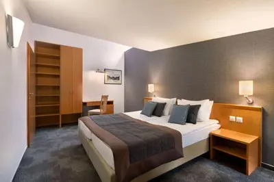 a hotel room with a large bed and a desk at Ramada Resort Kranjska Gora in Kranjska Gora