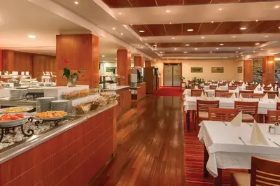 a restaurant with white tables and a buffet at Ramada Resort Kranjska Gora in Kranjska Gora