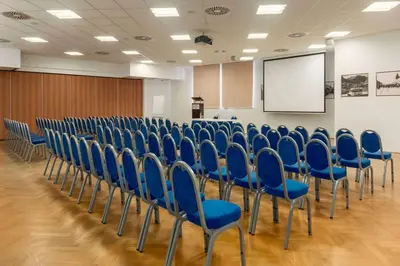 a lecture room with blue chairs and a screen at Ramada Resort Kranjska Gora in Kranjska Gora