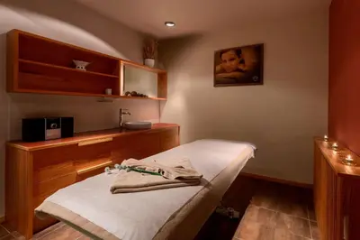 a small room with a bed and a sink at Ramada Resort Kranjska Gora in Kranjska Gora