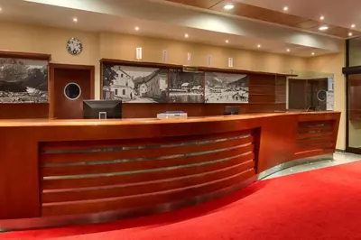 a lobby with a reception desk with a red carpet at Ramada Resort Kranjska Gora in Kranjska Gora