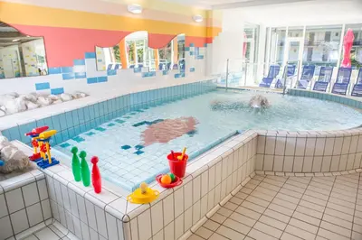 a large swimming pool with a person in the water at Hotel Kompas in Kranjska Gora