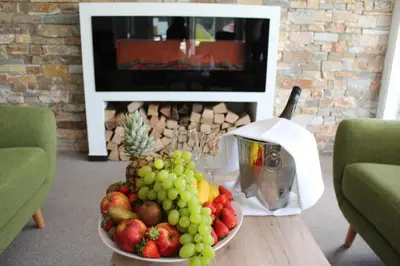 a bowl of fruit on a table in a living room at Hotel Alpina in Kranjska Gora