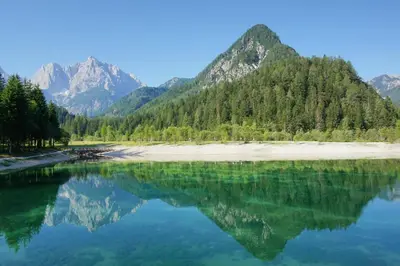 a large body of water with mountains in the background at Hotel Alpina in Kranjska Gora