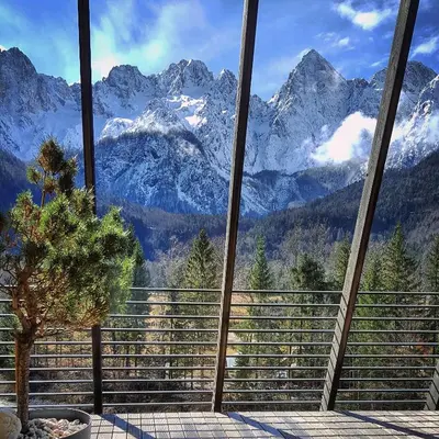 a view of a mountain range from a balcony at Hotel Špik in Kranjska Gora