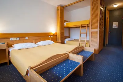 a bedroom with two bunk beds and a ladder at Hotel Špik in Kranjska Gora