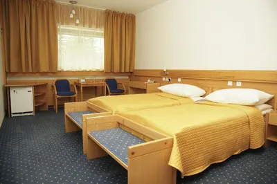 a hospital room with two beds and a table and chairs at Hotel Špik in Kranjska Gora