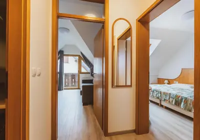 a hallway leading to a bedroom with a bed at Vitranc Apartments in Kranjska Gora