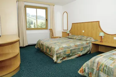 a hotel room with two beds and a window at Vitranc Apartments in Kranjska Gora