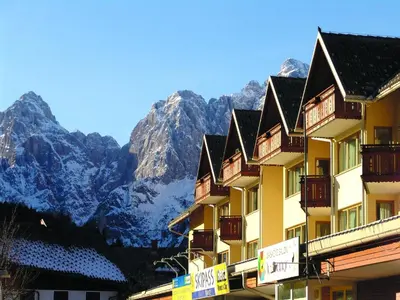 a hotel in front of a mountain with snow at Vitranc Apartments in Kranjska Gora