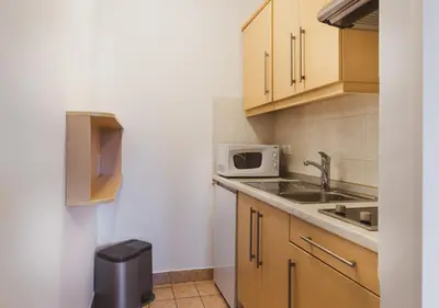a small kitchen with a sink and a microwave at Vitranc Apartments in Kranjska Gora
